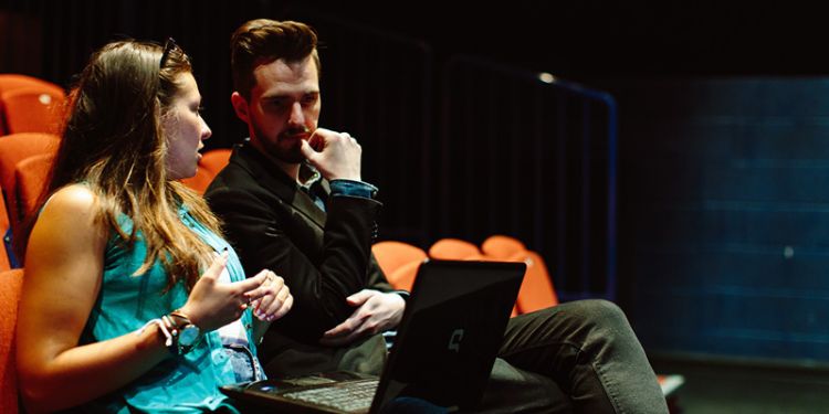 Students talking in theatre venue