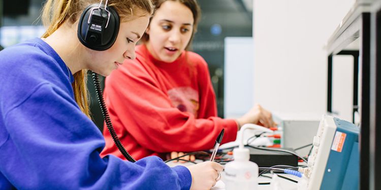 Two students using audio and translation technology.