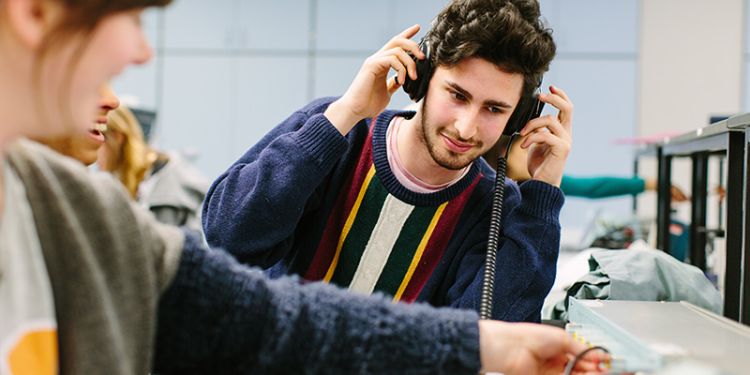 Student using audio equipment and headphones