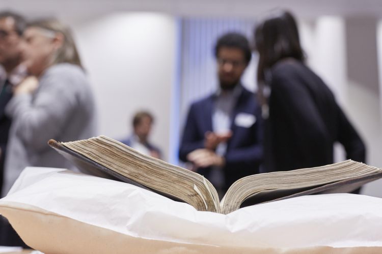 People chatting out of focus. Old book in focus.