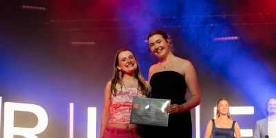 two LUUMIC representatives pose with a riley award on stage