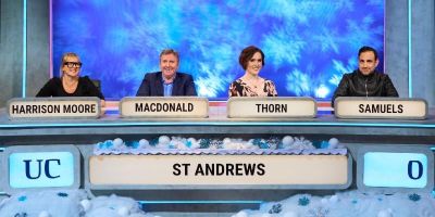 Four contestants in University Challenge with fake snow in foreground