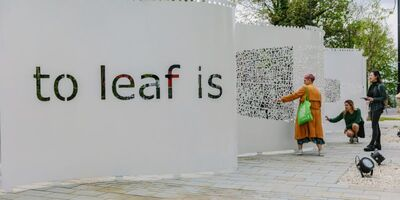 Sculpture of a white 'wall curtain' (taller than an average sized person) with black writing on it