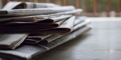 A picture of a pile of newspapers on a table.