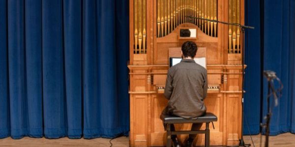 Male student practicing on the School of Music's organ in the Clothworkers Centenary Concert Hall.