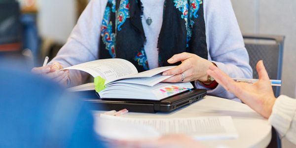 Book on a table being flipped through by a student.