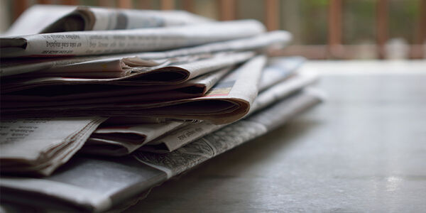 A picture of a pile of newspapers on a table.
