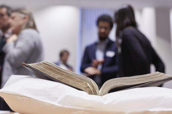 People chatting in background. Old book in focus.