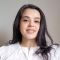Headshot of FAHACS MA student Maria Navaro. Maria stands against a light grey background and wears a white top, she is smiling.