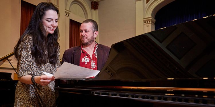 Student at piano with professor.