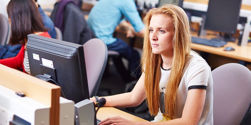 Student at a computer desktop in an IT suite